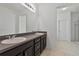 Bathroom showcasing double sinks, vanity with gray countertops, and tile flooring at 1407 Leitrim Loop, Apopka, FL 32703