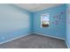 Bedroom with a large window, carpet, and a cute tree with owls wall design creating an playful atmosphere at 1407 Leitrim Loop, Apopka, FL 32703