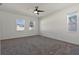 Spacious bedroom featuring neutral carpet, ceiling fan, and bright windows, offering comfortable living at 1407 Leitrim Loop, Apopka, FL 32703