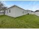 Exterior view of the home showcasing a fenced yard, well-maintained lawn, and neutral paint at 15120 Zenith Ave, Mascotte, FL 34753