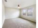 Neutral bedroom with carpet, light fixture, and natural light from the large windows at 15120 Zenith Ave, Mascotte, FL 34753