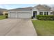 Charming single-story home with a well-manicured lawn, a two-car garage, and decorative window shutters at 15120 Zenith Ave, Mascotte, FL 34753