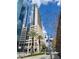 A tall, modern building with a glass facade, complemented by palm trees and vibrant street life in an urban setting at 155 S Court Ave # 2106, Orlando, FL 32801