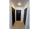 Hallway featuring neutral-colored walls and carpet leading to three black doors at 155 S Court Ave # 2106, Orlando, FL 32801