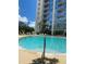 A sparkling swimming pool surrounded by lounge chairs, palm trees, and a modern building at 155 S Court Ave # 2106, Orlando, FL 32801