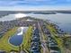 Stunning aerial shot of a community by a lake, showcasing waterfront living and well-kept homes at 15993 Johns Lake Overlook Dr, Winter Garden, FL 34787