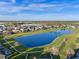 Scenic aerial view featuring a pond with fountain and mature trees at 15993 Johns Lake Overlook Dr, Winter Garden, FL 34787