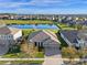 Aerial view of a home with a three-car garage, manicured lawn, and a beautiful pond in the backyard at 15993 Johns Lake Overlook Dr, Winter Garden, FL 34787