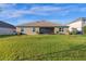 Spacious backyard showcasing a well-maintained lawn and the exterior of the home at 15993 Johns Lake Overlook Dr, Winter Garden, FL 34787