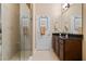 Bathroom with a glass shower, granite countertop, towel rack, and a tile floor at 15993 Johns Lake Overlook Dr, Winter Garden, FL 34787