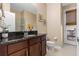 Well-lit bathroom featuring a granite countertop, dark wood cabinets, and access to the outdoor patio at 15993 Johns Lake Overlook Dr, Winter Garden, FL 34787