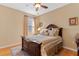 This bedroom has a ceiling fan, a window and a wooden bed frame with elaborate trim details at 15993 Johns Lake Overlook Dr, Winter Garden, FL 34787