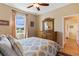 This bedroom features a bed with pillows and decorative throws, and a dresser with a large mirror at 15993 Johns Lake Overlook Dr, Winter Garden, FL 34787