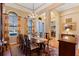 Bright dining room boasts wood floors, a crystal chandelier and large windows at 15993 Johns Lake Overlook Dr, Winter Garden, FL 34787