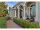 Elegant front entrance with brick pathway, arched entryway, and lush landscaping at 15993 Johns Lake Overlook Dr, Winter Garden, FL 34787