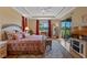 Main bedroom with large bed, tray ceilings, wood floors and an exterior view at 15993 Johns Lake Overlook Dr, Winter Garden, FL 34787