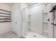 Bright bathroom featuring a shower with modern white walls and shelving, complemented by floating shelves at 1671 Spray Ter, St Cloud, FL 34771