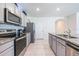 Well-equipped kitchen featuring sleek countertops, a stainless steel refrigerator, and modern appliances at 1671 Spray Ter, St Cloud, FL 34771