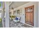 Close up of the front porch with seating, charming décor, and a beautifully crafted wood door at 1750 Winchester Dr, Winter Park, FL 32789