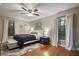 Well-lit bedroom with hardwood floors, a ceiling fan, and abundant natural light from the windows at 2614 W Ponkan Rd, Apopka, FL 32712