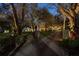 Long driveway and entrance with mature trees and landscaping lit up at dusk at 2614 W Ponkan Rd, Apopka, FL 32712