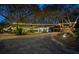 Exterior shot of home with a long driveway and string lights illuminating the mature trees at 2614 W Ponkan Rd, Apopka, FL 32712