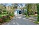 Driveway leading to a blue metal building surrounded by mature trees and landscaping at 2614 W Ponkan Rd, Apopka, FL 32712