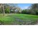 A large green lot is fenced with wood fencing and boasts mature trees at 2614 W Ponkan Rd, Apopka, FL 32712