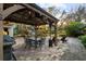 Landscaped outdoor patio area with a wooden gazebo containing a fan, lighting, grill, and a dining table at 2614 W Ponkan Rd, Apopka, FL 32712