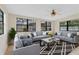 Bright living room with modern sofas, a geometric rug, and large windows offering backyard views at 2643 Nova Dr, Apopka, FL 32703