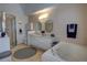 Bright main bathroom featuring dual sinks, a soaking tub, and a separate glass-enclosed shower at 304 Silver Pine Dr, Lake Mary, FL 32746