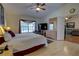 Comfortable main bedroom with a king bed, elegant decor, a ceiling fan, bright window, and ensuite access at 304 Silver Pine Dr, Lake Mary, FL 32746