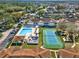 Overhead view of the community amenities, including a sparkling pool, a tennis court, and lush surroundings at 3206 Sabal Palms Ct # A, Kissimmee, FL 34747