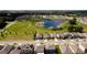 Aerial view of a residential neighborhood with a pond and well-maintained green spaces at 3332 Logan Berry Dr, Mount Dora, FL 32757