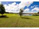 Backyard with lush lawn and a scenic lake view against a blue sky at 3332 Logan Berry Dr, Mount Dora, FL 32757