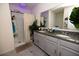 Bathroom showcasing a double vanity with granite countertops and a walk-in shower with shower curtains at 3332 Logan Berry Dr, Mount Dora, FL 32757