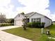 Attractive one-story home with well-kept lawn, two-car garage, and neat landscaping under a bright sky at 3332 Logan Berry Dr, Mount Dora, FL 32757