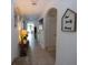 Inviting hallway featuring tiled floors, decorative wall art, and archways leading to other rooms at 3332 Logan Berry Dr, Mount Dora, FL 32757