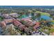 Aerial view showing town square buildings with red-tile roofs, palm trees, and waterfront at 340 Grand Canal Dr, Poinciana, FL 34759