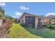 View of the screened-in porch and exterior elevation from the landscaped backyard with palm trees at 340 Grand Canal Dr, Poinciana, FL 34759