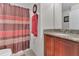 Bathroom featuring granite countertops, wood cabinets, a shower with decorative curtain, toilet, and towel rack at 340 Grand Canal Dr, Poinciana, FL 34759