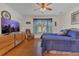 Bedroom with blue bedding features wood floors, a ceiling fan, and a large flatscreen television at 340 Grand Canal Dr, Poinciana, FL 34759