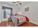 Cozy bedroom with wood floors, ceiling fan, and a window with decorative curtains at 340 Grand Canal Dr, Poinciana, FL 34759