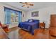 Bright bedroom features hardwood floors, ceiling fan, and natural light from a large window at 340 Grand Canal Dr, Poinciana, FL 34759