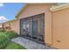 Inviting screened front porch with a stylish tile floor, a blue door, and decorative plants at 340 Grand Canal Dr, Poinciana, FL 34759