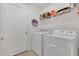 Functional laundry room with white washer and dryer, white door, and wire shelving for storage at 340 Grand Canal Dr, Poinciana, FL 34759