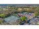 Aerial view of a complex of tennis courts surrounded by trees and parking areas at 340 Grand Canal Dr, Poinciana, FL 34759