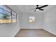 Bedroom with light wood floors, ceiling fan and two windows bringing in natural light at 3627 Arch St, Orlando, FL 32808