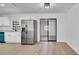 Spacious kitchen area with stainless steel refrigerator and bright lighting, next to sliding glass door to backyard at 3627 Arch St, Orlando, FL 32808