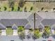 Aerial view of townhomes featuring a gray roof, green lawns, and street lined with parked cars at 3640 Solana Cir # A, Clermont, FL 34711